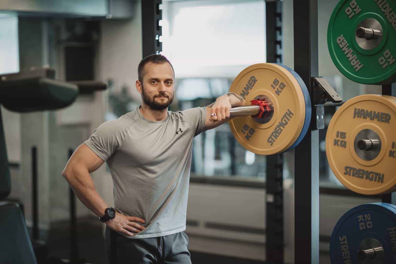 Trenér Jiří Kočvara opírající se o osu ve fitness centru TJ Lokomotiva Beroun.